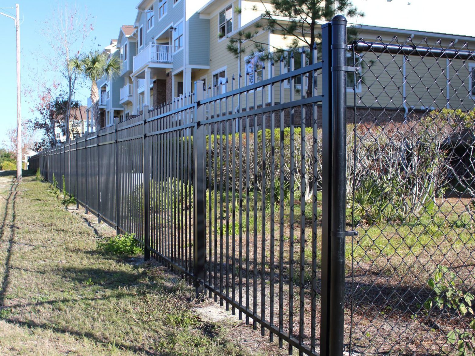 Photo of a black aluminum fence and chain link fence